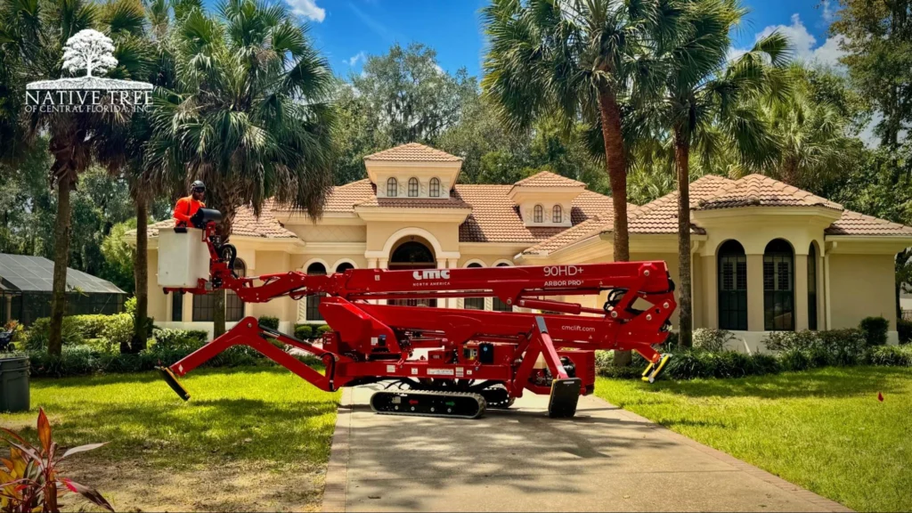 A red machine is parked in front of a house, ready for maintenance or construction work.